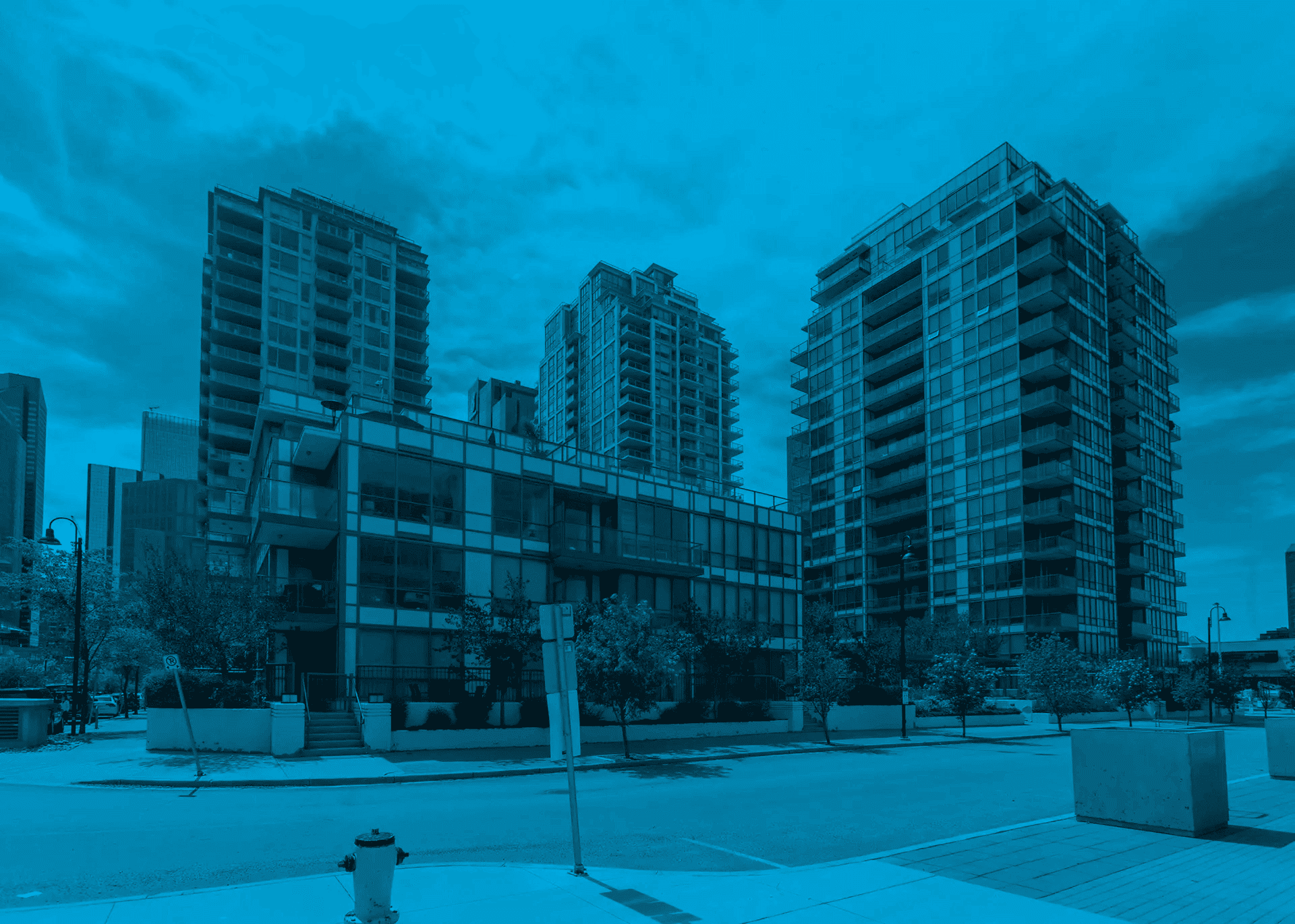 A street-level view of several modern residential high-rise buildings and luxury condo developments, representing the type of properties managed by condo board members.