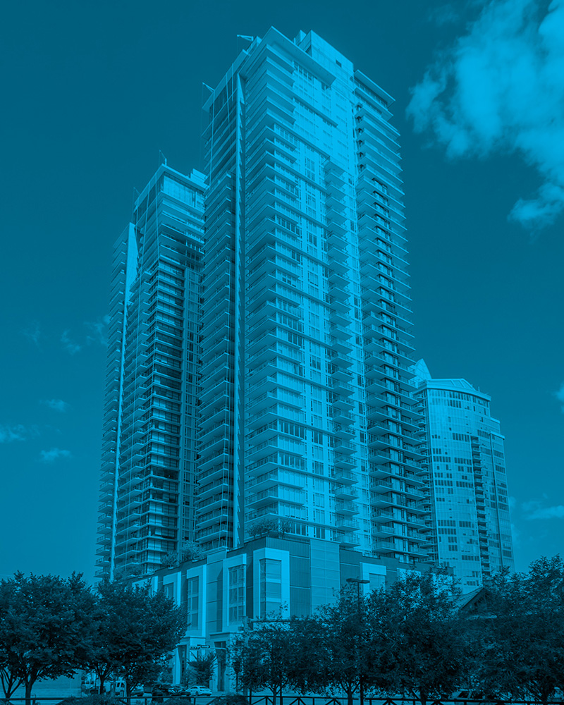 A tall, modern multi-unit residential building; a typical property where owners and tenants must distinguish the roles of property manager vs landlord regarding maintenance and lease oversight.