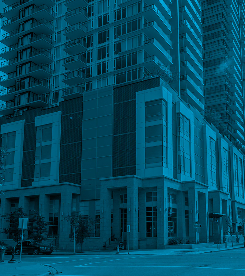 A tall, modern condominium building with glass balconies; an example of a multi-unit property that requires a healthy condominium reserve fund to cover major long-term repairs like roofing and structural maintenance.