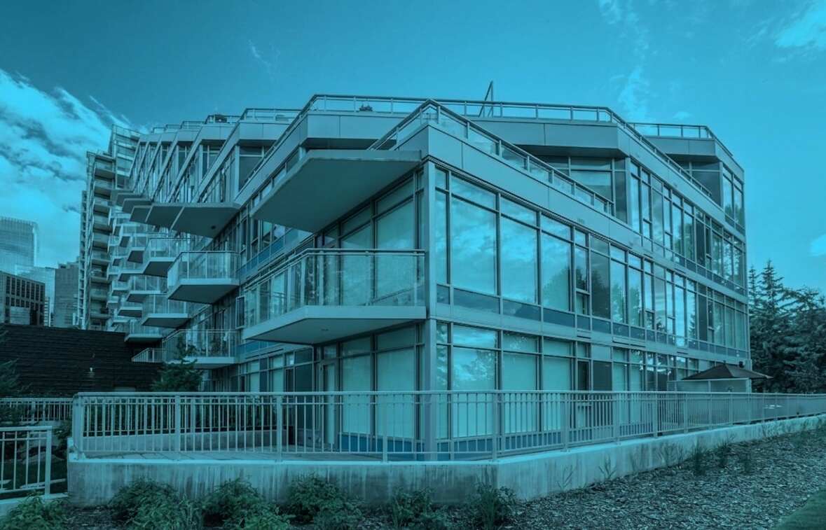 Modern condominium building exterior with balconies and glass windows, representing condo financial management and property investment planning.