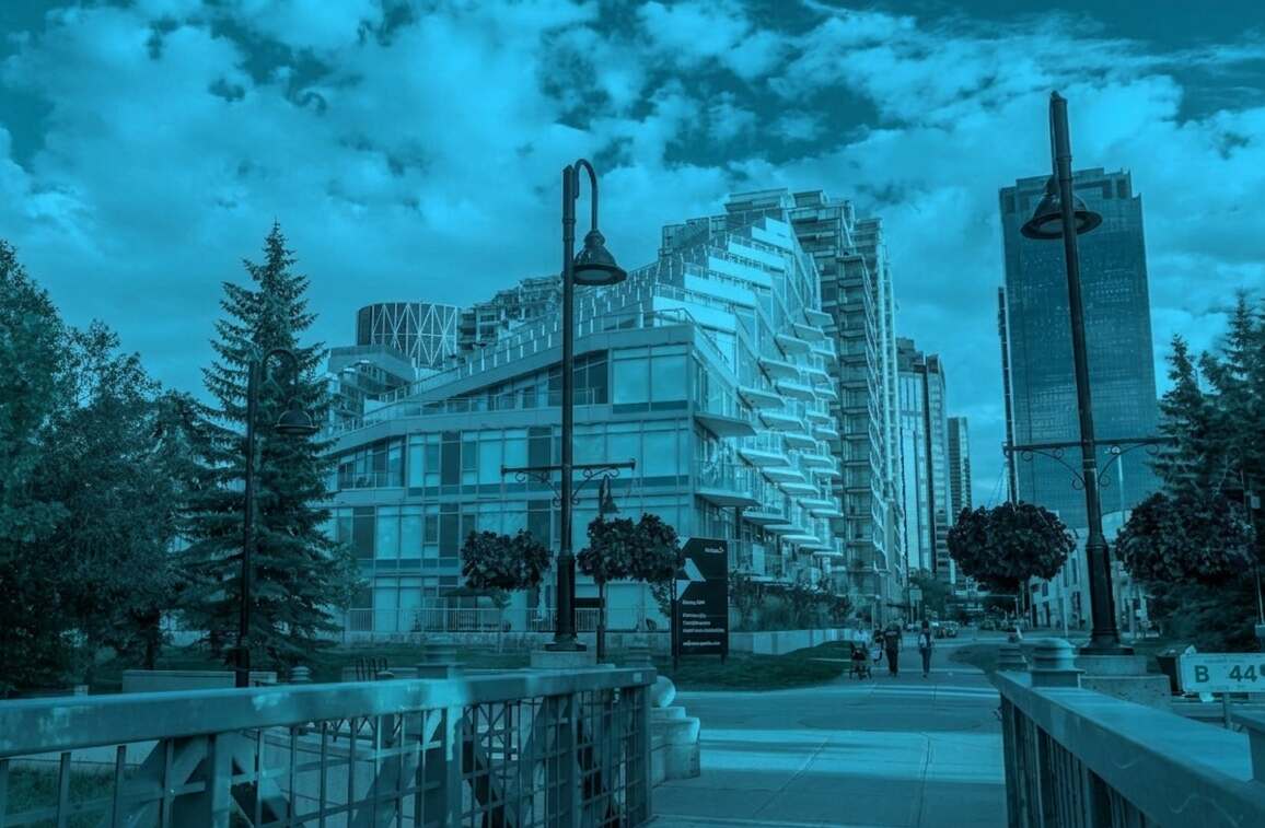 Urban condominium buildings and landscaped walkway with shared spaces, representing condo maintenance management and ongoing property upkeep.