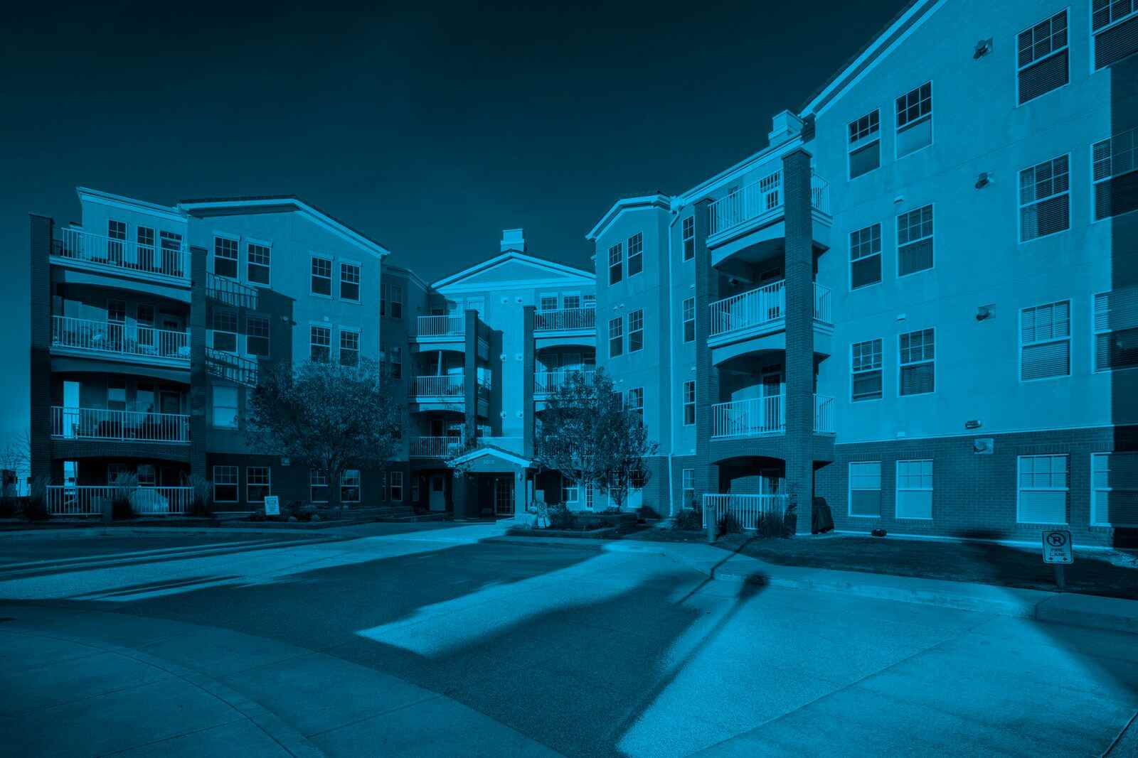 Multi-unit condominium complex with balconies and landscaped entrance, illustrating the roles of a condo board vs property manager in condominium community management.